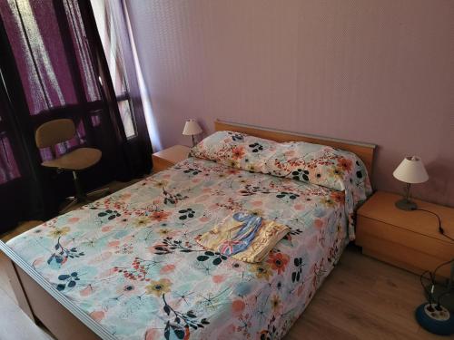 a bedroom with a bed with a floral bedspread at Chambre privée, proche Aéroport PARIS-Orly in Athis-Mons