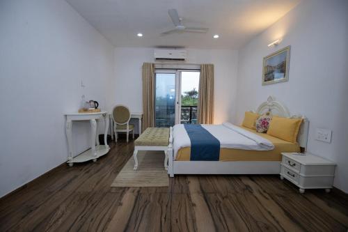a bedroom with a bed and a desk and a window at Amizunie's Boutique Hotel by SSAZ Hospitality in Udaipur
