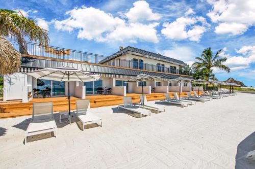 a row of chairs and umbrellas on a beach at Seaside at Anna Maria Island Inn in Bradenton Beach