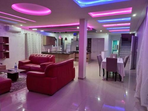 a living room with a table and purple lights at Magnifique villa avec piscine sur l’île de Djerba pour vacances in Arkou