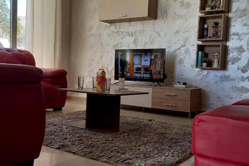 a living room with a table and a tv at Magnifique villa avec piscine sur l’île de Djerba pour vacances in Arkou