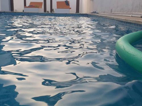 a swimming pool with a pool noodle in the water at Magnifique villa avec piscine sur l’île de Djerba pour vacances in Arkou