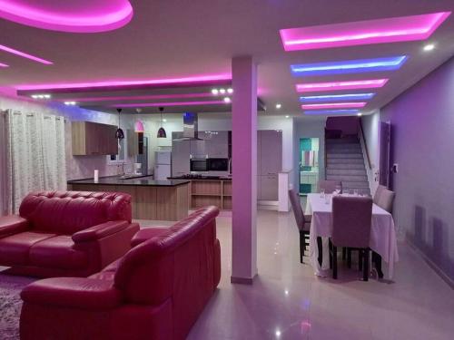 a living room with a dining table and purple lights at Magnifique villa avec piscine sur l’île de Djerba pour vacances in Arkou