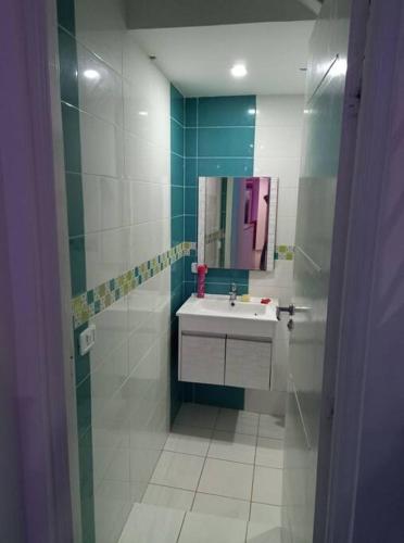 a bathroom with a sink and a mirror at Magnifique villa avec piscine sur l’île de Djerba pour vacances in Arkou