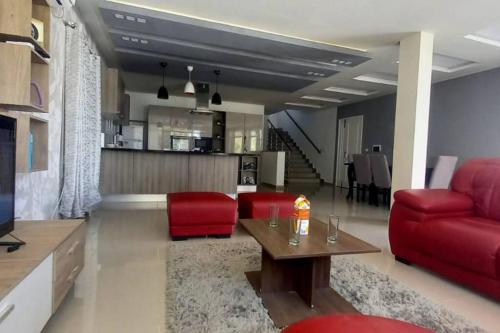 a living room with a red couch and a table at Magnifique villa avec piscine sur l’île de Djerba pour vacances in Arkou