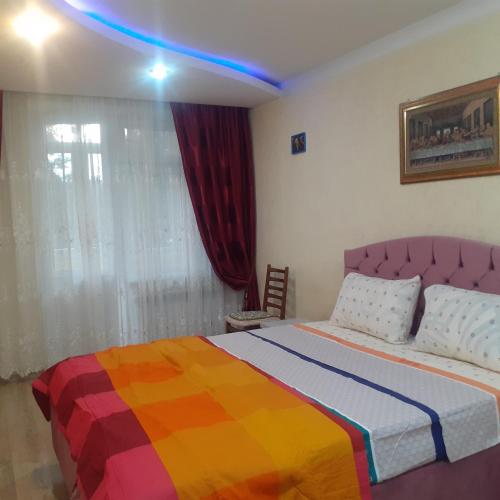a bedroom with a bed with a colorful blanket at Lachis@ Chisinau in Chişinău