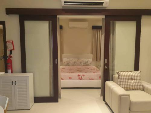 a bedroom with a bed and a couch and a chair at Acacia Flower AC 8-201 in Salalah