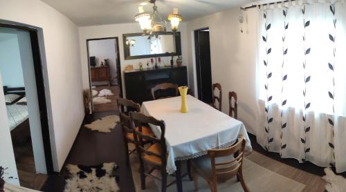 a dining room table with chairs and a vase on it at CASA RUSTIK in Bîltişoara