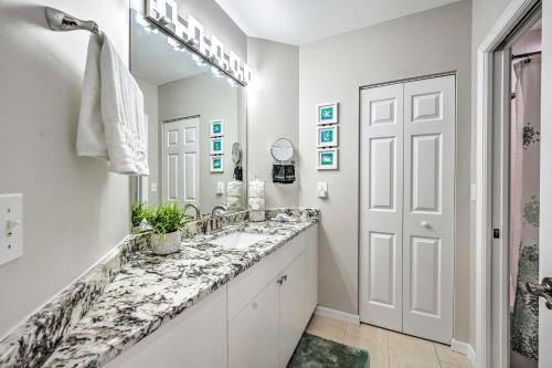 a white bathroom with a sink and a mirror at Naples Escape in Regatta with Resort Amenities! in Naples