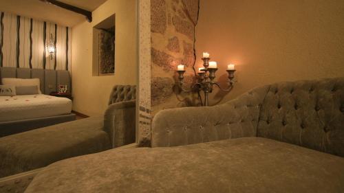 um quarto com 2 camas, um sofá e velas em Love Story - Lareira, Sauna & Piscina em Arcos de Valdevez
