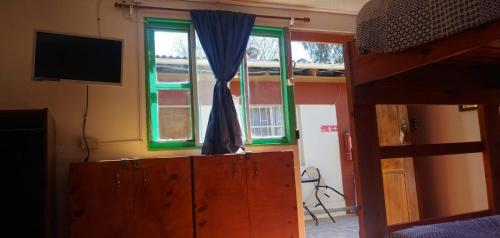 a bedroom with a bunk bed and a tv and a window at Hostal Michel in Vicuña