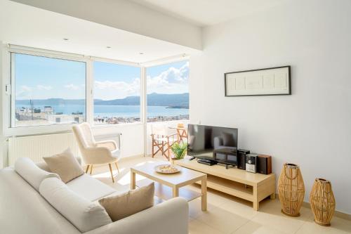 a living room with a white couch and a television at Mira Sitia Luxury Apartment in Sitia