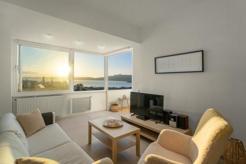 uma sala de estar com um sofá e uma televisão em Mira Sitia Luxury Apartment em Sitia