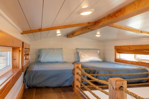 ein Schlafzimmer in einem winzigen Haus mit einem Bett in der Unterkunft Aloha Tiny Home in Apple Valley