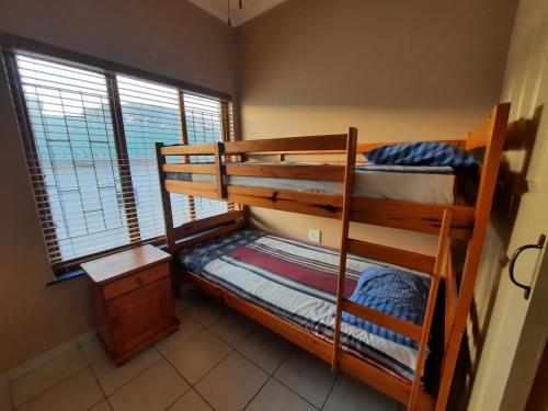 two bunk beds in a room with a window at Uvongo square Unit 24 in Uvongo Beach