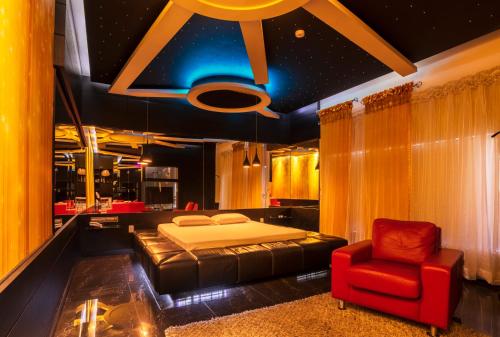 南卡希亞斯的住宿－Gran Motel Dubai，一间卧室配有一张床和一张红色椅子
