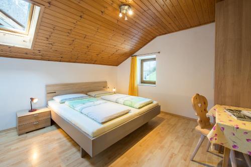 a bedroom with a bed and a wooden ceiling at Unterversanthof - Große Ferienwohnung für bis zu 6 Personen in Naturno
