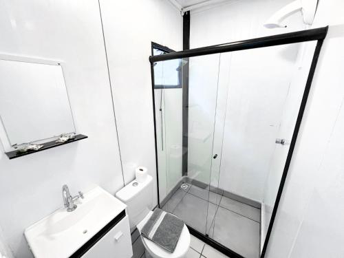 a bathroom with a shower and a toilet and a sink at 3x6 Lofts in Balneário Camboriú