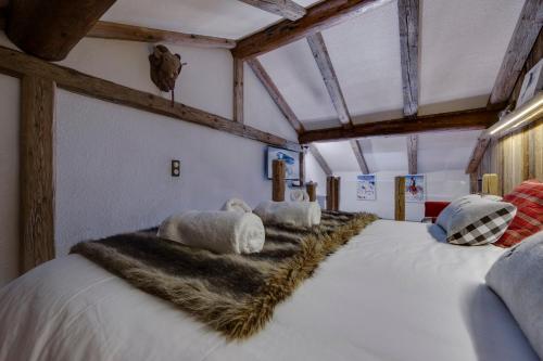 Appartement esprit chalet - splendide vue montagne في فال ديزير: سرير كبير في غرفة بسرير ابيض كبير مع وجود سفور فراء