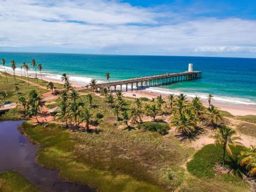 an aerial view of a pier on a beach with palm trees at Casa na Praia do Piruí - Arembepe in Arembepe