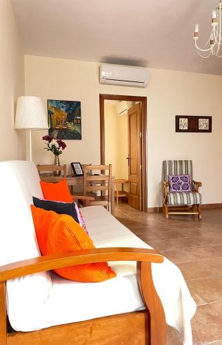 a living room with a white couch with orange pillows at LaFrenchTouch - Escapada rural en una coqueta casa in Villanueva de Tapia