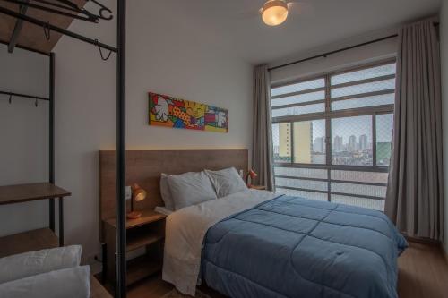 ein Schlafzimmer mit einem blauen Bett und einem Fenster in der Unterkunft Apartamento no Brás com Elevador in São Paulo