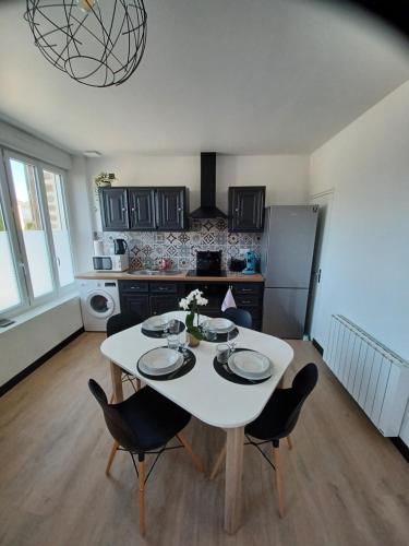 kuchnia z białym stołem i krzesłami w pokoju w obiekcie Nid douillet ernee w mieście Ernée