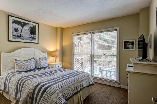 - une chambre avec un lit et une grande fenêtre dans l'établissement Mooring Buoy, à Île de Hilton-Head