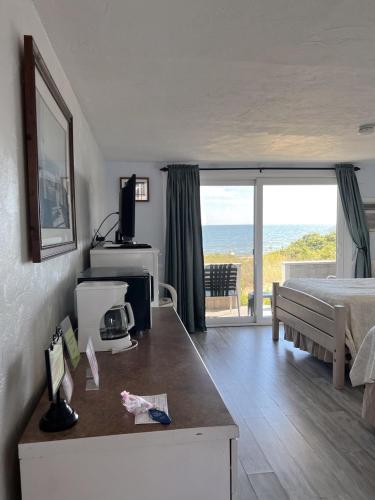 ein Schlafzimmer mit Bett und Meerblick in der Unterkunft Seashell Motel in Dennis