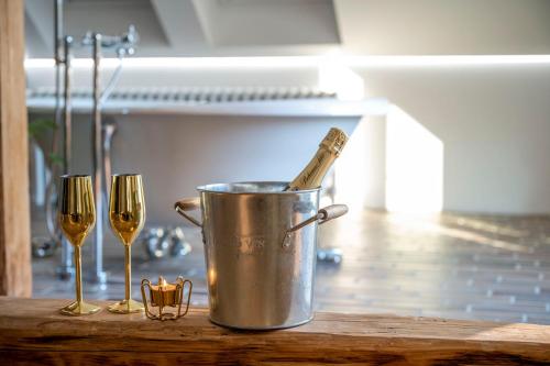a bucket with a champagne bottle in it next to two wine glasses at Vila Na Landeku in Ostrava