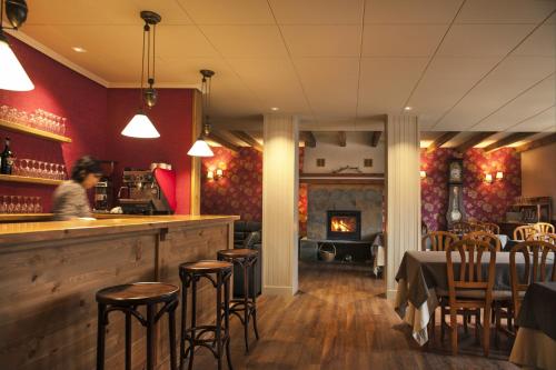a woman sitting at a bar in a restaurant at Hotel Deth Pais in Salardú