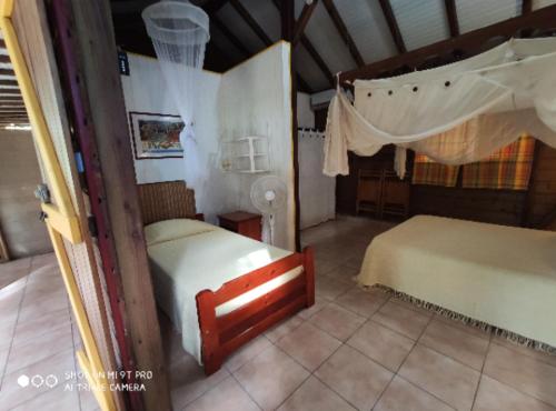 a bedroom with two beds in a room at Bakoulélé en Guadeloupe in Bouillante