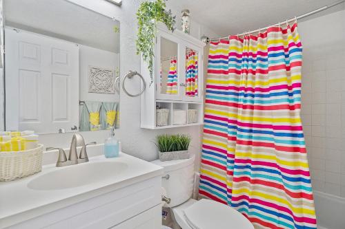 un bagno con tenda colorata accanto a servizi igienici di Aloha Hibiscus Room,Sunset Views - Hawaiian Inn Beach Resort a Daytona Beach Shores