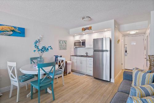 una cucina e una sala da pranzo con tavolo e frigorifero di Aloha Hibiscus Room,Sunset Views - Hawaiian Inn Beach Resort a Daytona Beach Shores