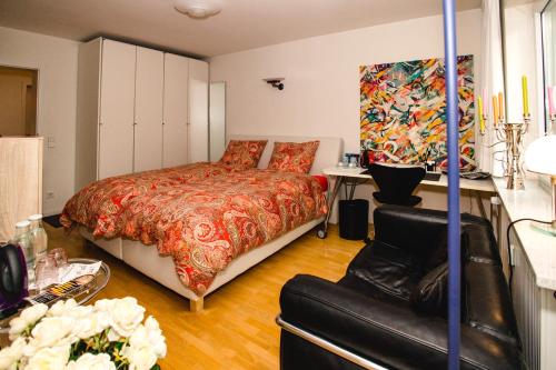 1 dormitorio con 1 cama y 1 sofá en Modernes und gemütliches Designerzimmer en Langensteinbach
