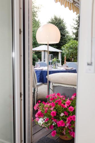 a table and chairs on a porch with pink flowers at Modernes und gemütliches Designerzimmer in Langensteinbach
