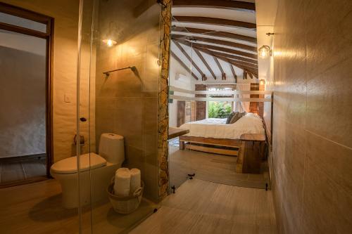 ein Bad mit WC und ein Bett in einem Zimmer in der Unterkunft PETRA SANTA HOTEL BOUTIQUE in Pereira