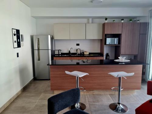 a kitchen with a refrigerator and two bar stools at Mendoza Chill in Mendoza
