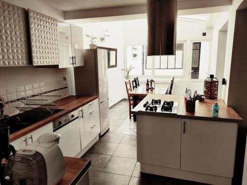 une cuisine avec des placards blancs et un comptoir dans l'établissement Superbe maison rénovée avec agréable jardin, à Sainte-Catherine
