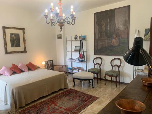 ein Schlafzimmer mit einem Bett, Stühlen und einem Kronleuchter in der Unterkunft Il Loggiato in Castelfranco Veneto