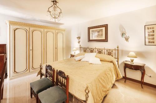 una camera con un letto e due sedie e un lampadario a braccio di Dimora Bellavista,garage privato,due piani a Sanremo