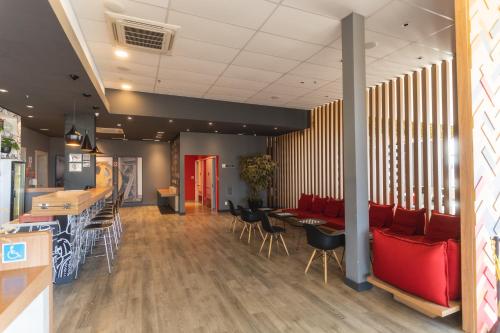 a restaurant with red chairs and tables and a bar at Ibis Lorena - Circuito da Fé in Lorena