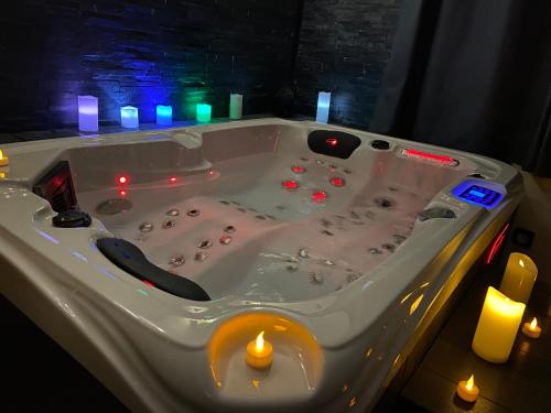eine Whirlpool-Badewanne mit Kerzen in einem Zimmer in der Unterkunft le tricosy jacuzzi et sauna privatif in Tricot