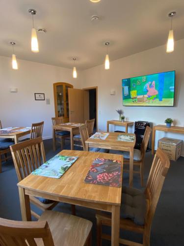 a dining room with tables and chairs and a flat screen tv at Ferienunterkunft mit 4 Doppelzimmern in Einbeck!! in Einbeck
