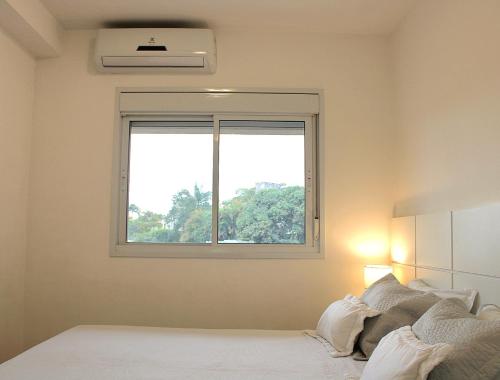 a white bedroom with a window and a bed at Apartamento 50m2 Hospital Einstein Morumbi in Sao Paulo