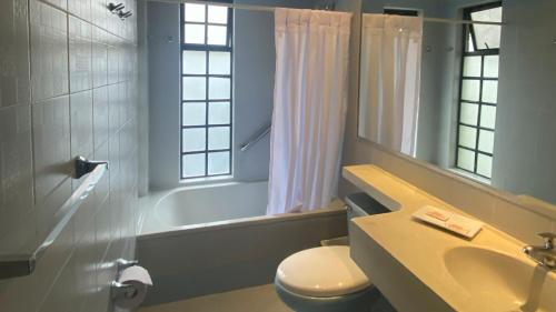 a bathroom with a tub and a toilet and a sink at On Vacation Girardot Resort in Girardot