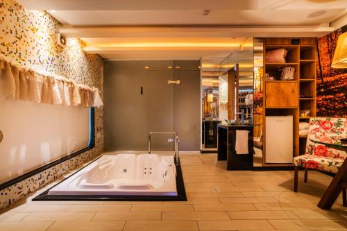 una grande vasca da bagno in una camera con divano di Gran Motel Dubai a Caxias do Sul