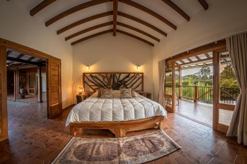 a bedroom with a bed and a balcony at PETRA SANTA HOTEL BOUTIQUE in Pereira