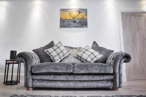 a couch with pillows on it in a living room at Laburnam Villa - Luxury 4 bedroom accommodation in the heart of Killin in Killin