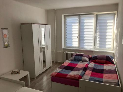ein kleines Schlafzimmer mit einem Bett und einem Fenster in der Unterkunft Byt v blízkosti centra in Klášterec nad Ohří